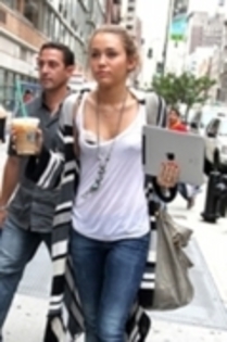 Holding A Coffee and Ipad Leaving Starbucks In New York CA