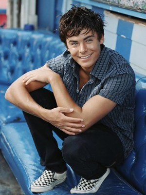 Zac_Efron_blue_seat_crouched_down_looking_away_smile_181007 - poze high school musica