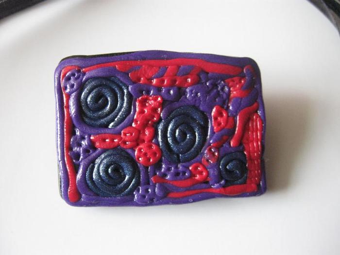 Detaliu brosa; Mov, siclam, albastru inchis pe fond negru. 30 lei
