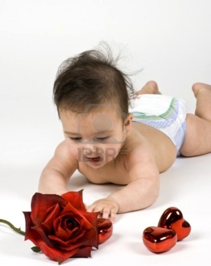 4103807-a-sweet-little-baby-girl-reaching-for-a-rose-and-some-heart-shaped-ornamets