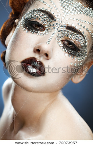 stock-photo-beauty-woman-makeup-with-crystals-on-face-on-blue-background-72073957