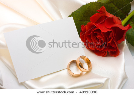 stock-photo-two-gold-wedding-rings-red-rose-and-card-over-white-satin-40913998