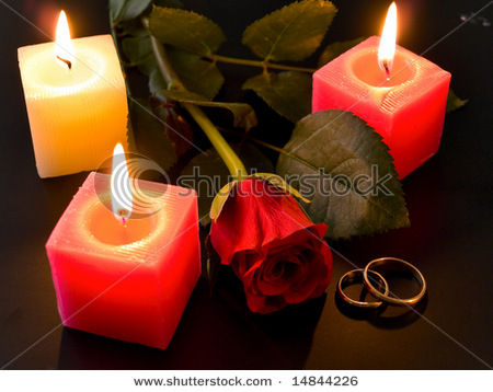 stock-photo-wedding-rings-rose-and-candles-in-night-14844226