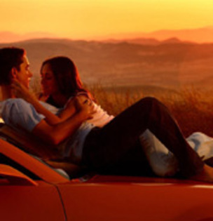 Romantic_Lovers_On_Car_And_Sunset