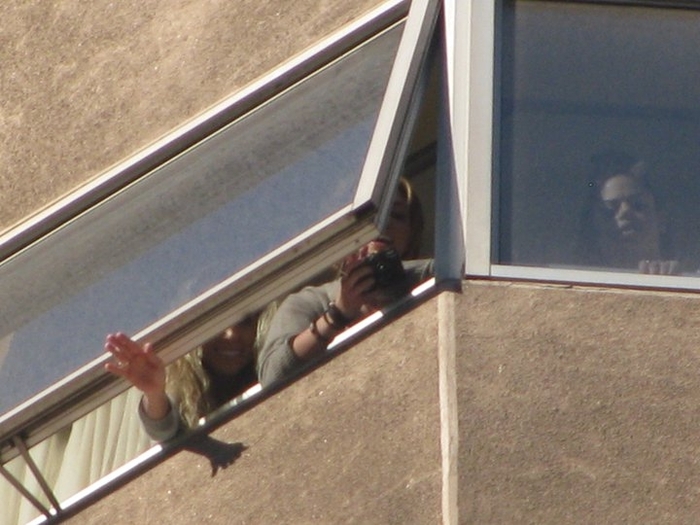 001~55 - Miley Cyrus waving to fans from their hotel window in Chile