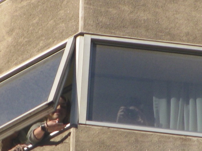 004 - Miley Cyrus waving to fans from their hotel window in Chile