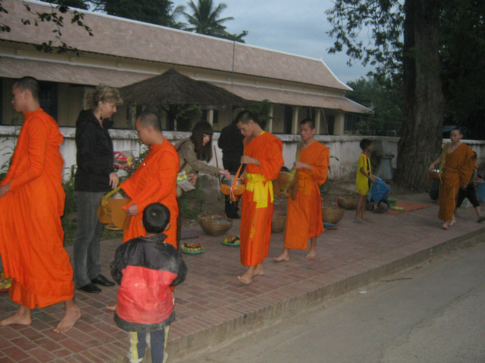 Luang Prabang - defilarea calugarilor budisti carora zilnic, in zori, primesc ofrande