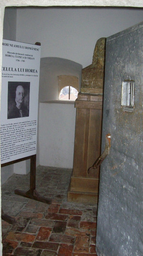 100_3061In interiorul celulei ,panoul ,o ferestruica a celulei,bustul lui Horea ,si usa grea de meta - Celula lui Horia de pe poarta a treia a cetatii Alba Iulia