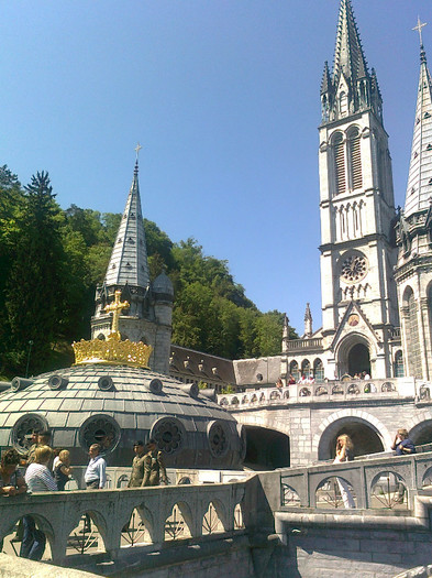 LOURDES (30); suntem pe terasa de la primul etaj.Observam luminatorul circular al bisericii de la parter, una din cele doua porti de acces al unuia din cele doua turnuri aferente bisericii de la et.I
