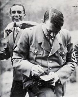 Hitler dind autografe; f amuzat,la fel ca si Gobbels,in spatele lui
