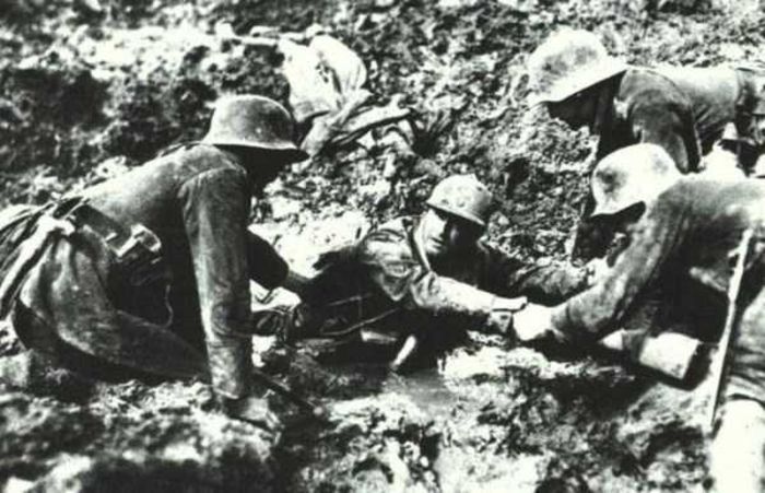1914; Soldati germani incercind sa salveze un soldat francez dintr-o groapa cu noroi( 1914-1918)
