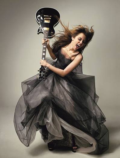 0401-miley-cyrus-raising-guitar_lg - Miley Cyrus breakout