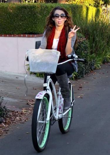 miley_cyrus_rides_her_bike_while_the_porsche_waits_in_the_garage