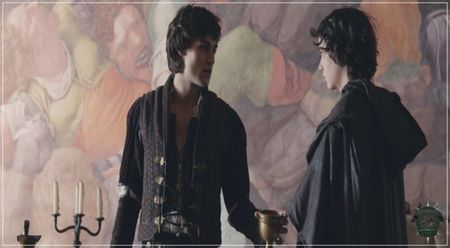 ♛ Crezi? Mie mi se pare prostesc acum. (râde scurt după care aprobă din cap) Sigur. (se opresc; la margine de drum unde se dă jos de pe cal, legându-l de o creangă dintr-un copac, după care se întoarce spre Morrigan, ajuntând-o)
