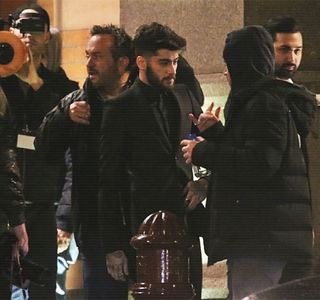 — retrage palma de pe talia ei, ulterior ba chiar ocolindu-i și corpul, ca în cele din urmă să; înainteze spre trotuarul ce avea să-i poarte spre înlănțuirea tarabelor deja zărite ale târgului. Totuși, atunci când ambele palme și le introduce în buzunarele gecii, se oprește în loc și privește
