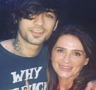 ━ Gâtul acestuia, de asemenea, plasându-i un sărut fugitiv pe obraz. Odată înfăptuit gestul; respectiv, îşi sprijină una dintre palme de suprafaţa blatului, cealaltă revenindu-i proptită în şold, clipă în care se amuză totodată de reacţia sa ulterioară. „Ei bine, cum tu nu erai prezent,
