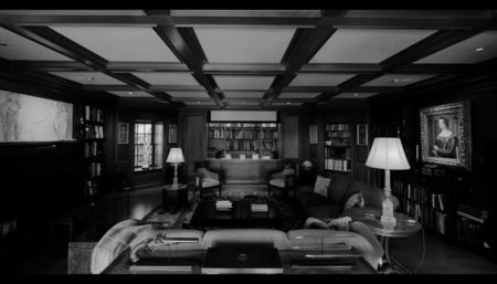 of the woods, the flicker of candlelight—, the quiet rhythm of rain tapping against the wide glass; windows. Inside, the air is thick with warmth—the scent of burning wood, faint traces of his cologne lingering in the fabric of the couch where Amory sits curled up, one arm draped over the backrest, 
