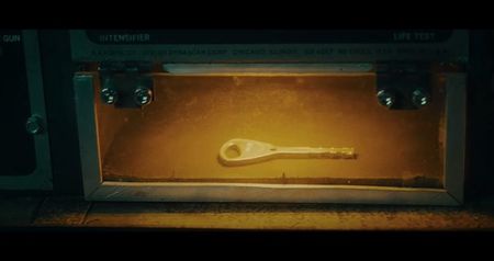 revealing a small brass key. But before anyone can move, the mirror flashes—and a holographic; image plays against its surface: a courtroom photo of Amir, shaking hands with the lead Helios scientist.
