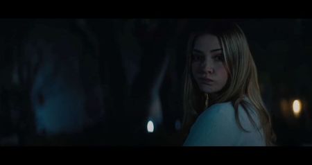 mechanical headset of sharpened metal pieces resembling a halo. A monitor flickers to life,; displaying grainy footage from years ago—Margot in a white coat, standing in front of a young patient strapped to a chair. She’s smiling. She wasn’t just a painter, she was once an artist-in-residence
