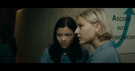 Sylvia writes something on the wall with her finger dipped in the toxin: “Confession = Cure?”