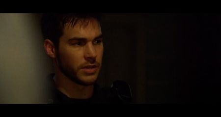 Beneath his ribs, a small circular device is lodged deep in the muscle—its light flickering; weakly before fading out. Blood trickles down his side, pooling beneath him. Sylvia keeps repeating: “No—no, no, no...” while shaking.
