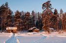 2219330-a-small-wooden-house-in-a-snow-forest-on-sunset
