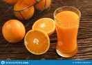 jus-d-orange-frais-en-verre-grand-avec-le-panier-des-oranges-sur-bois-131486190