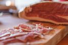 close-up-of-cured-ham-on-chopping-board-738786073-5a67d337ff1b780037e575d7