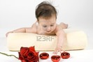 4103814-a-sweet-little-baby-girl-reaching-for-a-rose-and-some-heart-shaped-ornamets