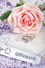 5320144-with-love-tag-in-front-of-pink-rose-and-rings-on-satin-and-lace-heart-pillow
