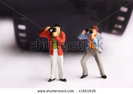 stock-photo-photographers-miniature-figurines-standing-near-a-roll-film-41681548