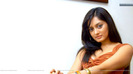 Parvati-Vaze-Sitting-On-A-Chair-In-Orange-Top-Good-Pose
